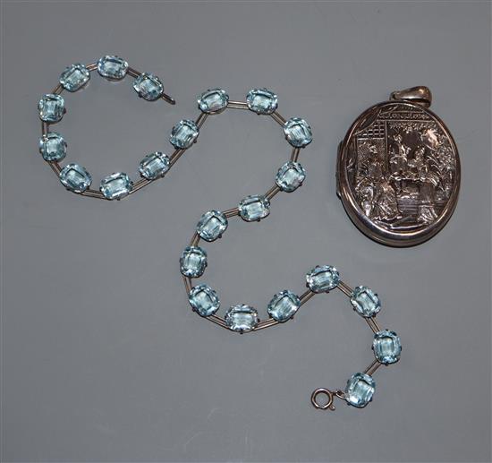 An embossed white metal oval locket and a blue paste set riviere necklace.